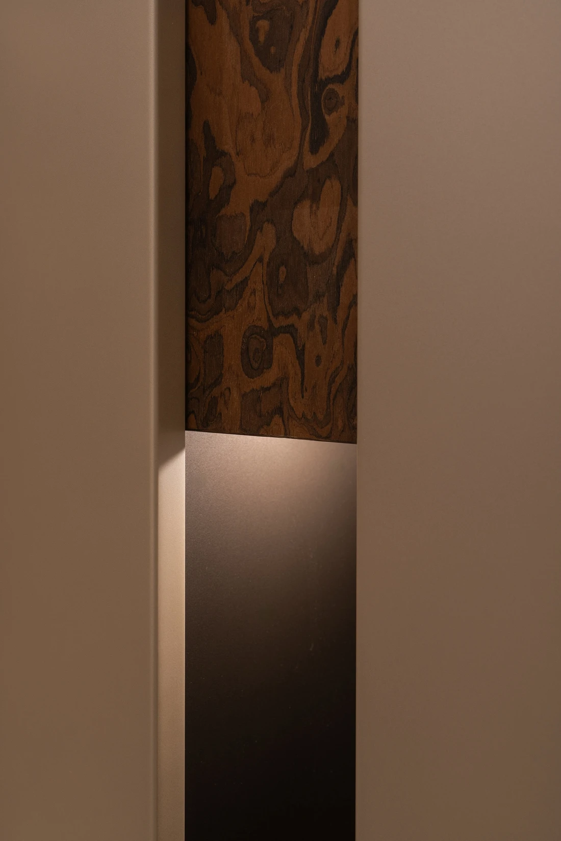 Franja de madera veteada entre frentes claros, con un hueco iluminado debajo