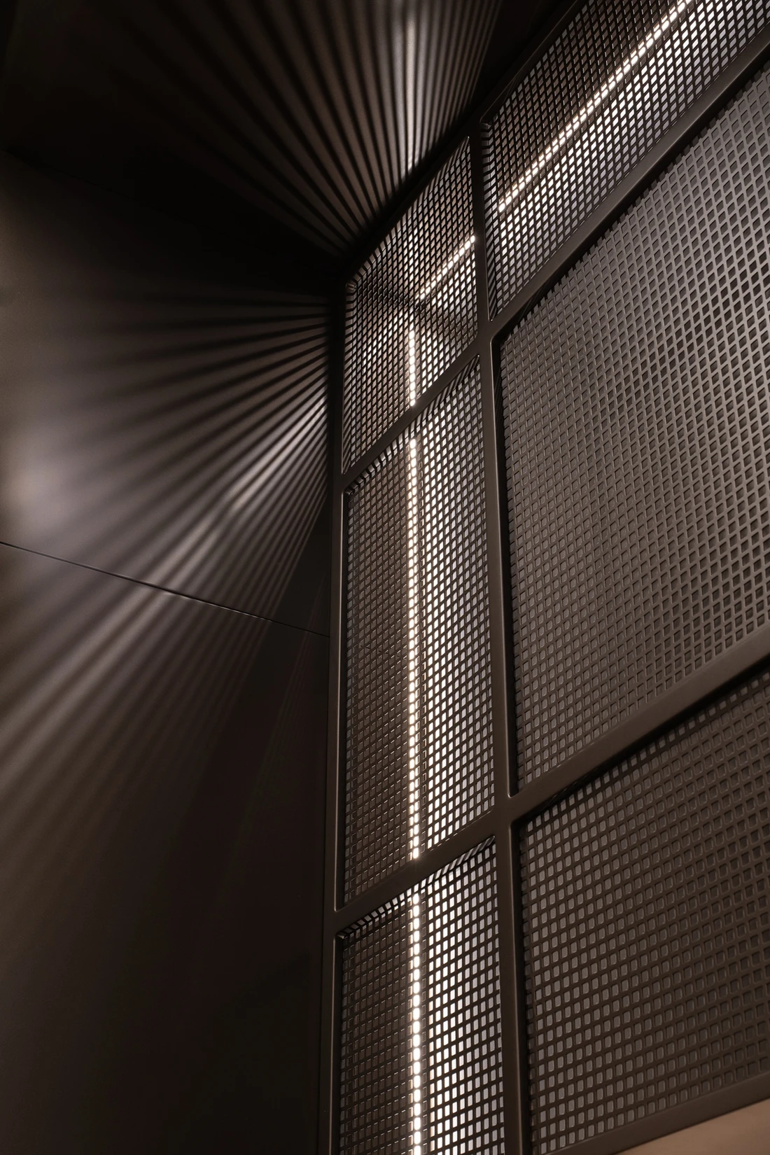 Panel perforado iluminado desde dentro que proyecta su trama de luz sobre las paredes
