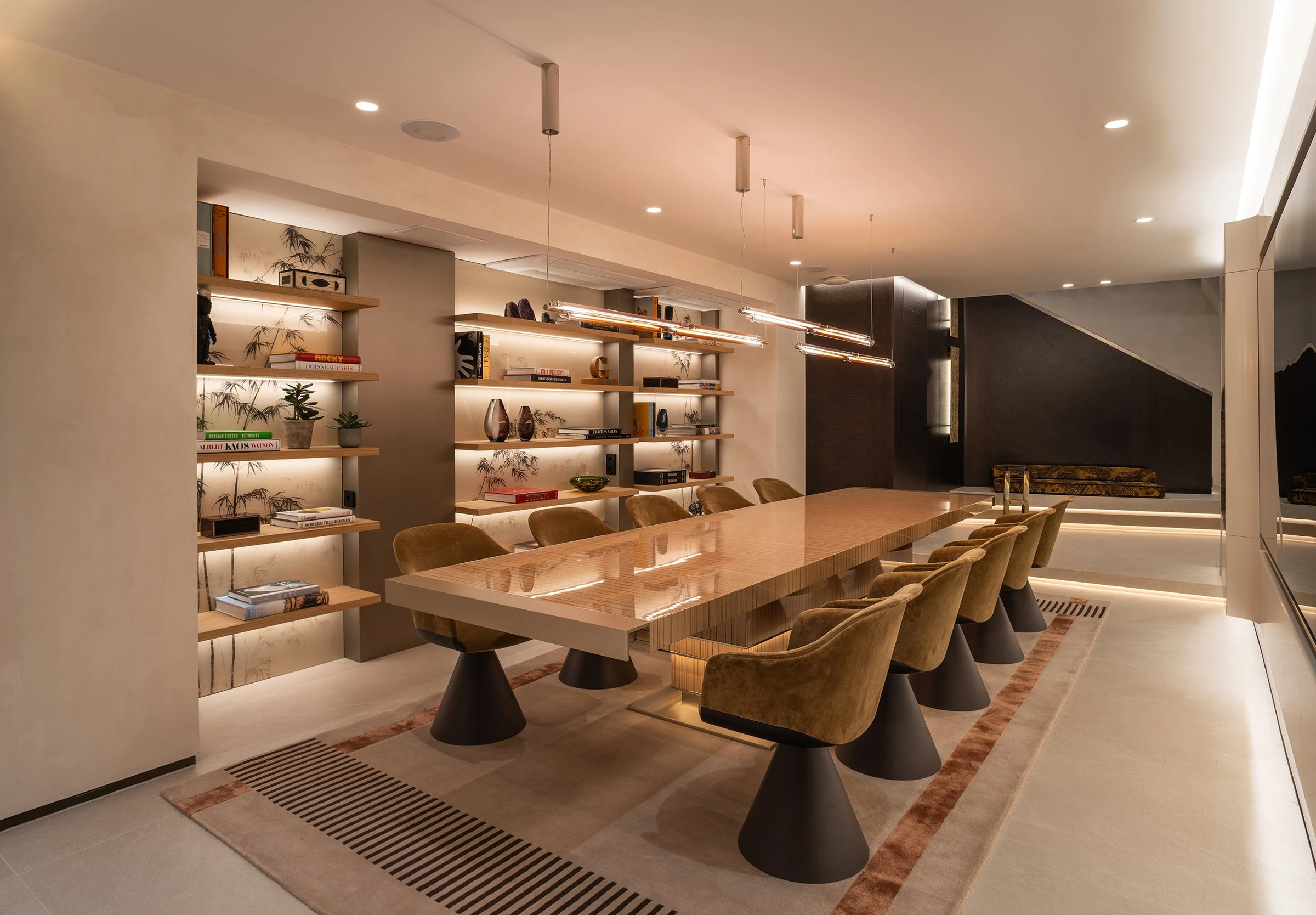 Sala de reuniones con mesa larga y estanterías iluminadas